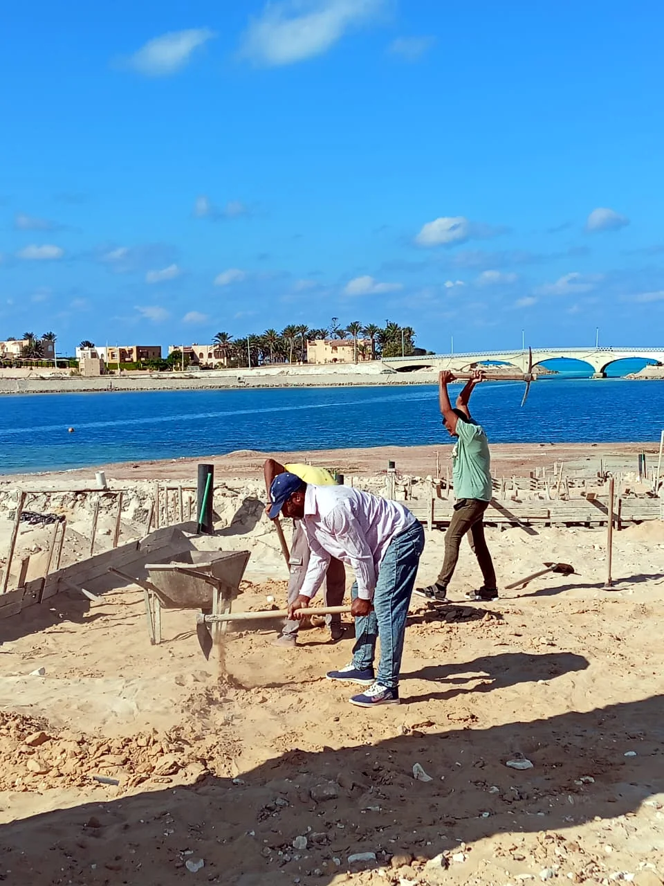 عمال ينفذون أعمال تجهيز الأرض بالموقع